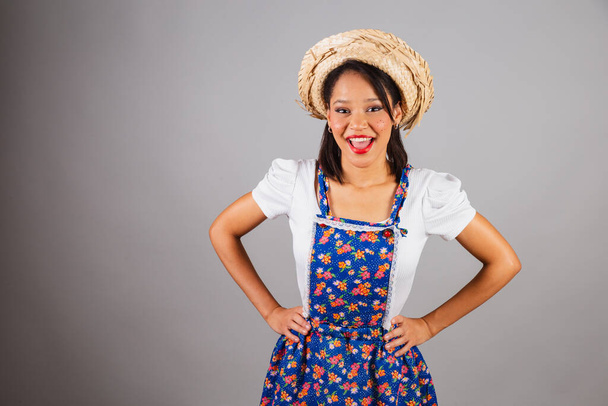 Brazilian woman, northeastern, with June party clothes, straw hat. Hands on hips. - 写真・画像