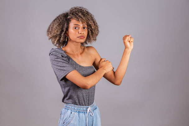 black Brazilian woman, beautiful, fist clenched, posing for photos. militancy, female resistance, empowerment. - Fotó, kép