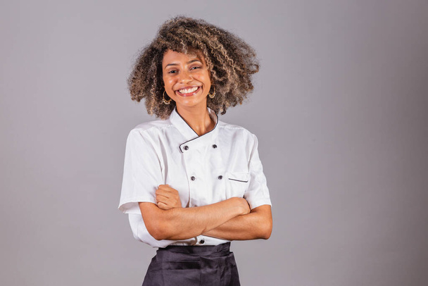 Young black Brazilian woman, cook, masterchef, wearing restaurant uniform. arms crossed, optimistic and confident. - Φωτογραφία, εικόνα