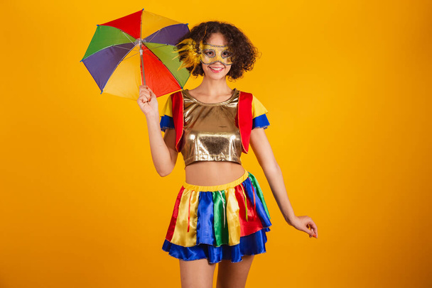 Beautiful Brazilian woman, dressed in frevo clothes, dressed for carnival. using colorful umbrella. - Foto, Imagem