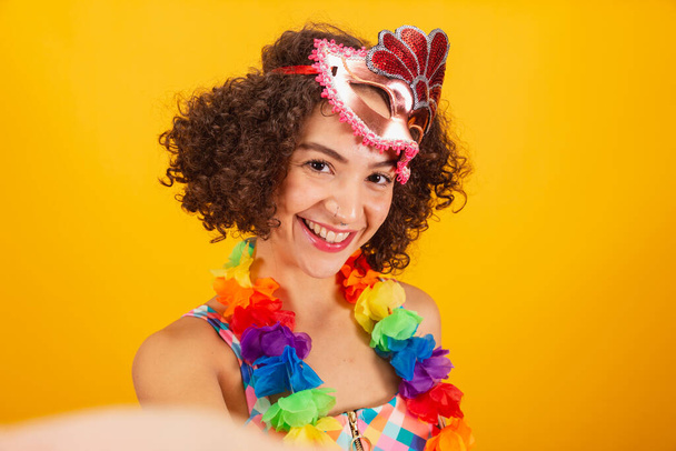 Beautiful Brazilian woman, dressed in carnival clothes, close-up photo on her face, selfie. - 写真・画像
