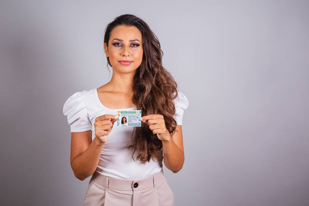 Brazilian woman, brown hair, holding driver's license, Brazilian document. - 写真・画像