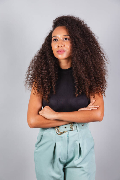 vertical photo, beautiful black Brazilian woman, looking at camera, curly hair. - Fotó, kép