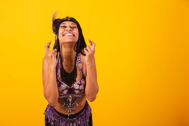 beautiful black brazilian woman, in purple carnival clothes, cheering hard, wishing. - Photo, image