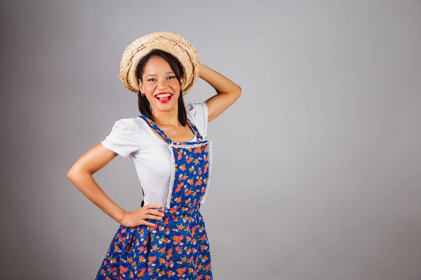 Mujer brasileña, noreste, con ropa de fiesta de junio, sombrero de paja. Manos en la cintura y el sombrero. - Foto, Imagen