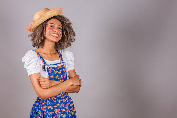 Young black Brazilian woman, with country clothes, dressed for Festa Junina. Saint John's festival. arms crossed, happy, smiling. - Photo, Image