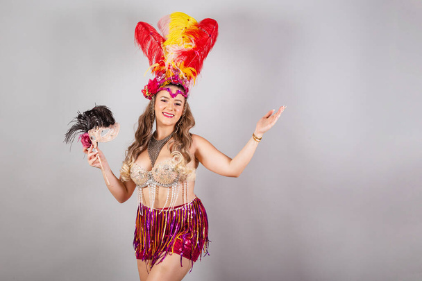 Horizontal, half body shot, beautiful Brazilian woman in carnival clothes. holding carnival mask. - Fotó, kép