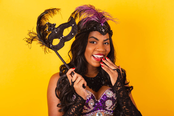 Horizontal, half body shot of beautiful black Brazilian woman in carnival clothes. holding carnival mask. wow, amazing - Foto, Imagem
