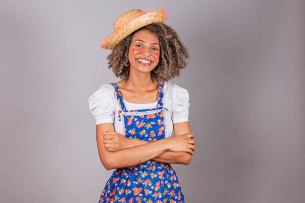 Young black Brazilian woman, with country clothes, dressed for Festa Junina. Saint John's festival. arms crossed, happy, smiling. - Foto, imagen
