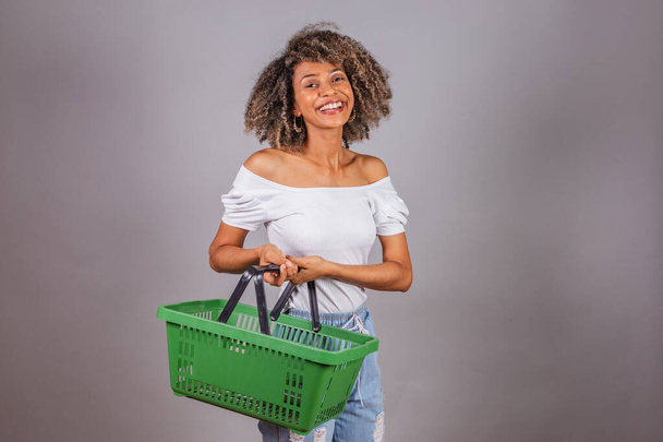 beautiful black Brazilian woman holding market shopping basket, shopping, advertisement, discount, promotion. - Фото, изображение
