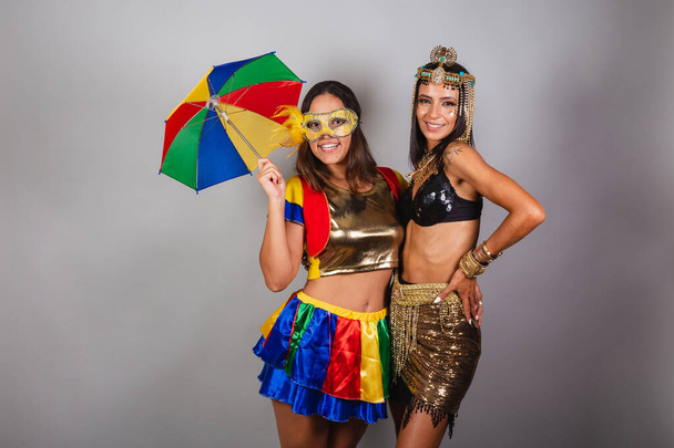 Horizontal, half-body shot of two Brazilian friends in carnival outfits. posing for photo. - Zdjęcie, obraz