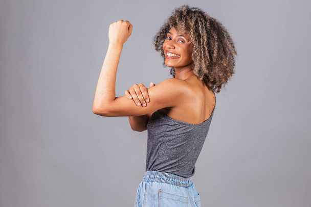 zwarte Braziliaanse vrouw, mooi, vuist gebald, poseren voor foto 's. strijdbaarheid, vrouwelijke weerstand, empowerment. - Foto, afbeelding