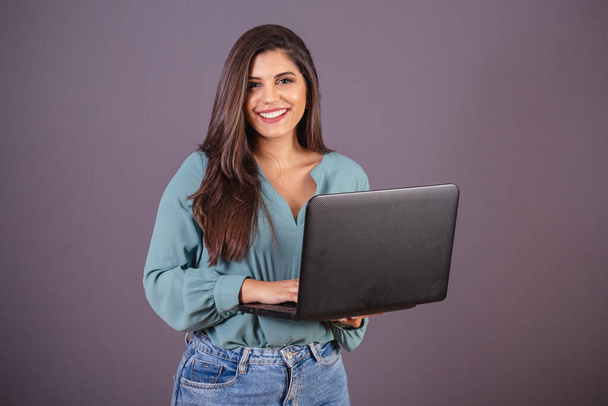 Horizontal photo. Beautiful Brazilian woman, with casual clothes, Jeans and green shirt. with notebook. - Φωτογραφία, εικόνα