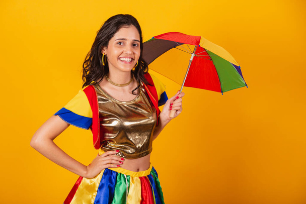 beautiful brazilian woman in carnival clothes, with frevo clothes, and colorful umbrella. - Photo, image