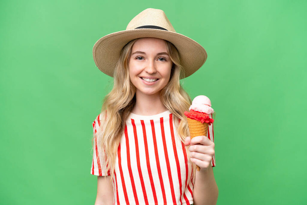 Young English woman with a cornet ice cream over isolated background smiling a lot - Фото, зображення