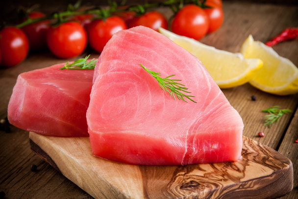 Surowy tuńczyk filet z koperkiem, cytryny, Wiśniowe pomidory i oliwy z oliwek - Zdjęcie, obraz