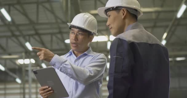 bukósisakot viselő férfi munkavállalók a gyárban - Felvétel, videó