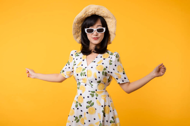 Πορτρέτο νεαρή χαρούμενη ασιατική γυναίκα ευτυχισμένη χαμόγελο ντύσιμο άνοιξη θηλυκό στυλ μόδας και γυαλιά ηλίου που απομονώνονται σε κίτρινο φόντο. ελκυστικό όμορφο κορίτσι μοντέλο που θέτουν συναίσθημα έννοια καλοκαίρι. - Φωτογραφία, εικόνα