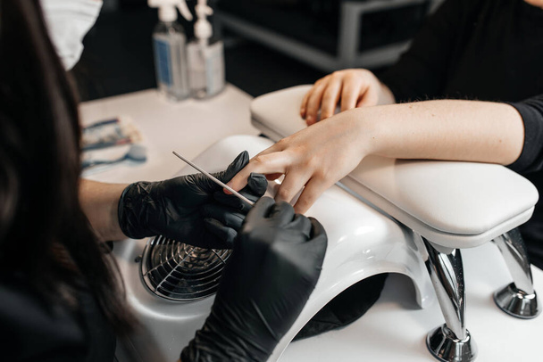 the process of creating a hygienic manicure with a nail file - Valokuva, kuva