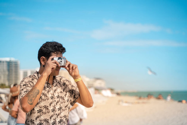Gli uomini in spiaggia di Miami con macchina fotografica in vacanza scattano una foto. orizzontale Foto di alta qualità - Foto, immagini