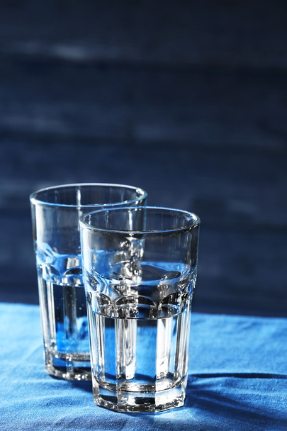 Two glasses of water on table on wooden background - Zdjęcie, obraz