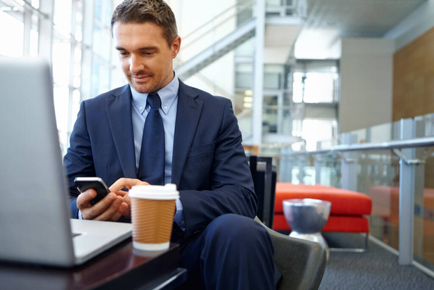 Businessman with smartphone, focus and company communication or social media with coffee while working. Contact, online and email with networking, b2b and worker in professional corporate lounge. - Photo, Image