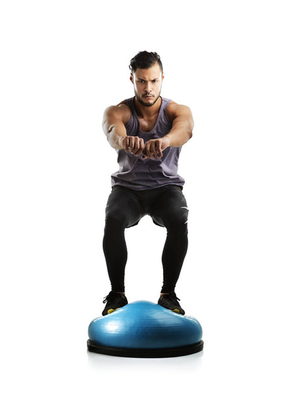 Its all about balance. Studio shot of a fit young man working out with a bosu ball against a white background - Φωτογραφία, εικόνα