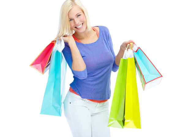 I just cant help myself. An excited young woman holding shopping bags while isolated on a white background - Фото, изображение
