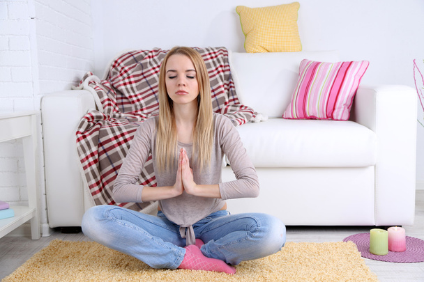 Young woman doing yoga at home - Foto, afbeelding