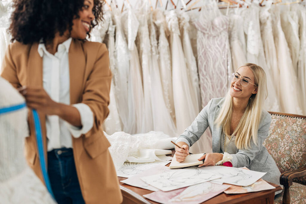Two women work together in a bridal salon as a tailor and a designer. - Φωτογραφία, εικόνα
