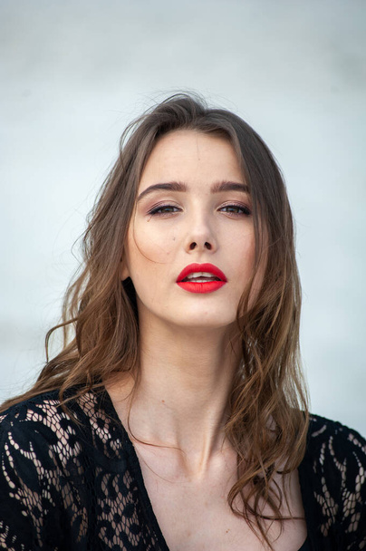 belle jeune femme aux cheveux longs et aux lèvres rouges posant en studio - Photo, image