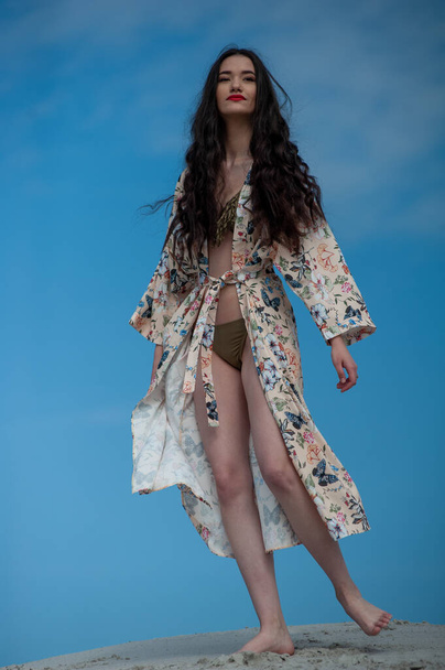 beautiful young woman in a swimsuit posing on the beach - Фото, зображення
