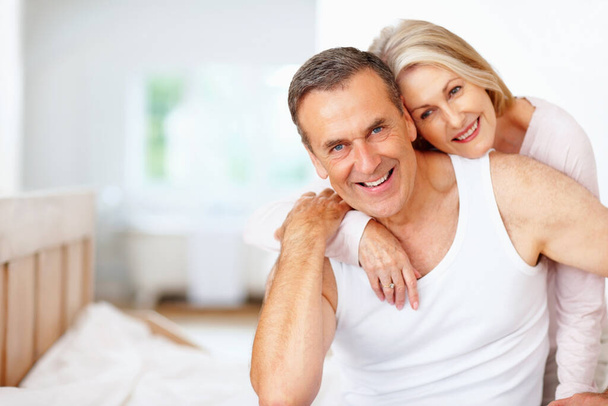 Улыбающийся взрослый мужчина с женой проводит время вместе. Портрет улыбающегося взрослого мужчины с женой, проводящего время вместе - Фото, изображение
