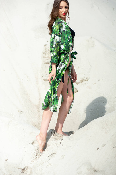 beautiful young woman in swimsuit posing on beach - Fotó, kép
