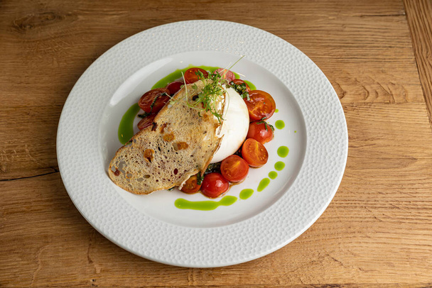 delicious buratta cheese on a white plate - Фото, зображення