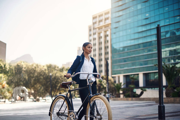 Transport, marche et femme d'affaires avec un vélo dans la ville, le matin et la rue pour la routine de travail. Employée respectueuse de l'environnement, voyageuse et professionnelle se rendant au bureau à vélo dans une ville urbaine. - Photo, image