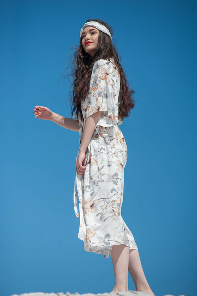 bela jovem mulher em um vestido branco em um fundo azul - Foto, Imagem