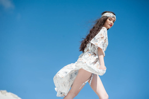 hermosa mujer joven vestida de blanco sobre un fondo de cielo azul - Foto, Imagen