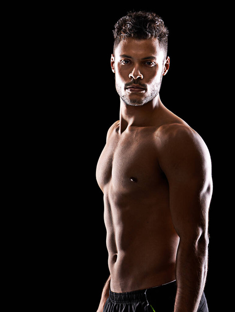 Zapadají tam, kde stojíš ty. Studio portrét pohledného nahého mladého sportovce stojící ve stínu - Fotografie, Obrázek