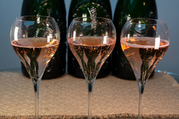 Degustación de vino espumoso de champán rosa brut en las bodegas de la casa de vinos Gran Cru en Epernay, tour de vinos en Champagne, Francia, botellas de magnum en el fondo - Foto, Imagen
