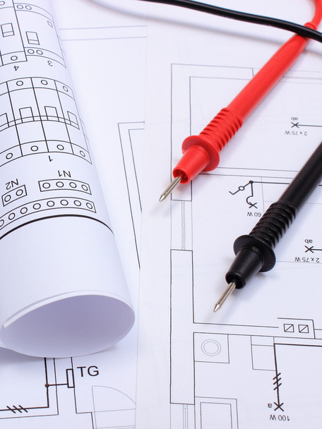 Diagramas elétricos laminados e cabos de multímetro no desenho da casa
 - Foto, Imagem