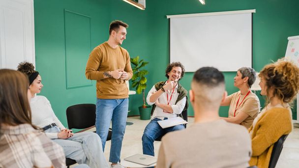 A group of people sitting in a circle with therapists man and a woman discussing and providing emotional support solving problem mental awareness and stigma self care concept - Photo, Image