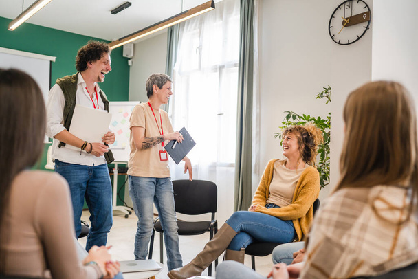 A group of people sitting in a circle with therapists man and a woman discussing and providing emotional support solving problem mental awareness and stigma self care concept - Photo, Image