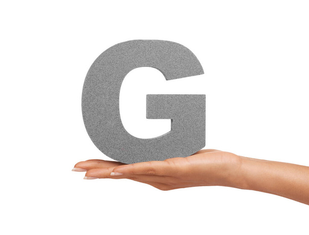 Give it up for the letter G. A young woman holding a capital letter G isolated on a white background - Fotoğraf, Görsel