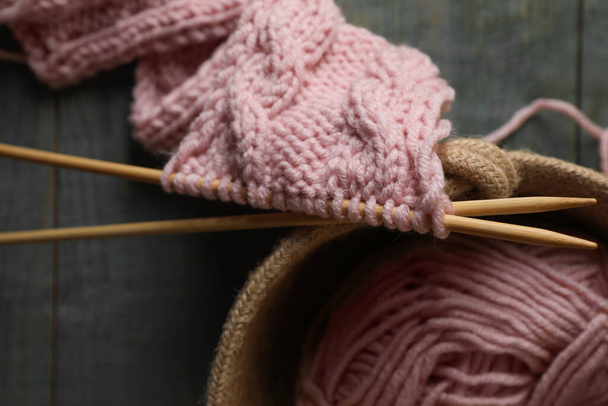 Soft pink woolen yarn, knitting and needles on wooden table, top view - Fotografie, Obrázek