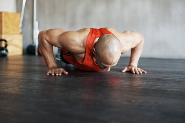 Fitness, floor exercise and man doing push up for strength workout, gym practice or bodybuilder training. Endurance challenge, discipline and strong male athlete doing studio exercises on ground. - Foto, imagen