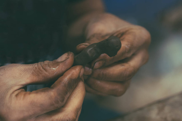 Craftsman working the clay with his hands to make figures for spectacular ornaments. - 写真・画像