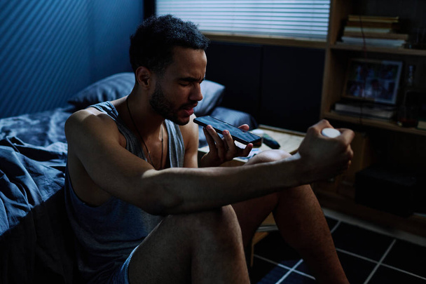 Молодой человек с посттравматическим расстройством записывает голосовое сообщение, консультируясь о лекарствах со своим психиатром - Фото, изображение