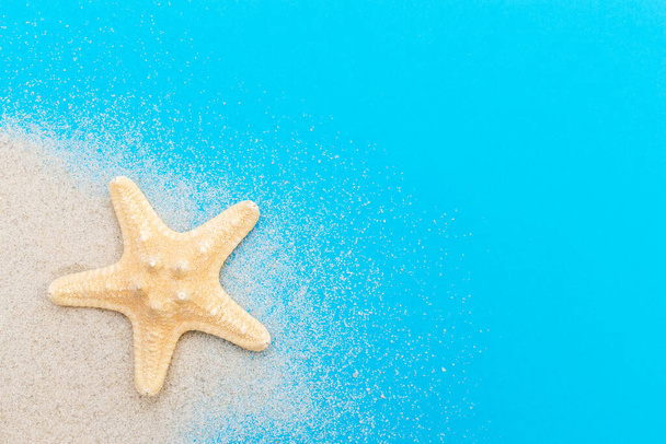Estrella de mar con arena sobre un azul. Vista superior. Fondo de verano. - Foto, Imagen