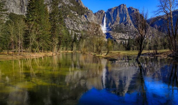 Blick auf die Yosemite Falls mit einem Schneekegel und einer Spiegelung im Frühling im Yosemite Nationalpark, Sierra Nevada Gebirgskette in Kalifornien, USA - Foto, Bild